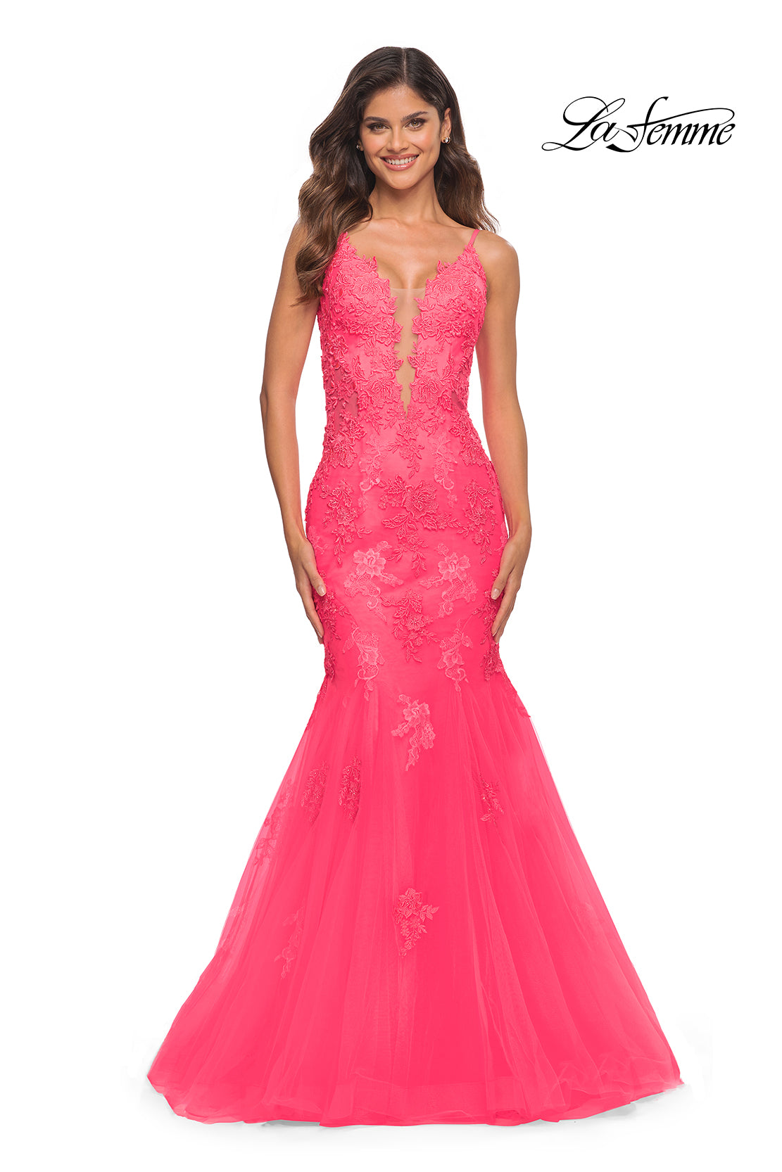 A woman stands and smiles brightly in the La Femme Neon Pink Long Mermaid Prom Dress, featuring lace detailing, a floor-length hem, and a sleeveless design.